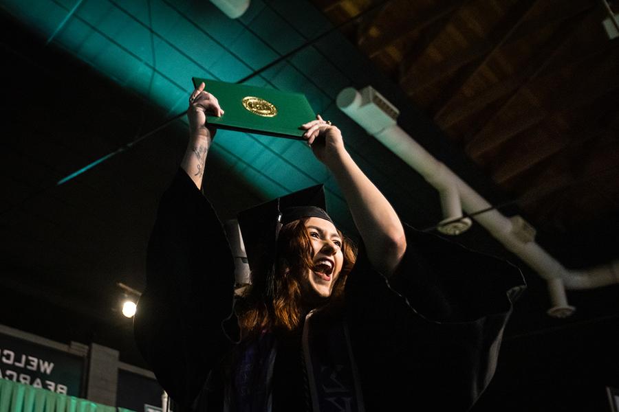 周六，<a href='http://coi.getrealcuba.com'>和记棋牌娱乐</a>的一名毕业生在毕业典礼上展示她的毕业证书.
